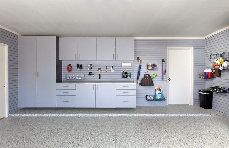 Garage organization storage systems. Silver cabinets, stainless countertops, gray slatwall.